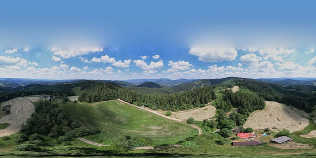 A spherical panoramic photograph from the signpost on the ridge meadow – a wooden shelter and a signpost with direction plates, open meadow and spruce forest around