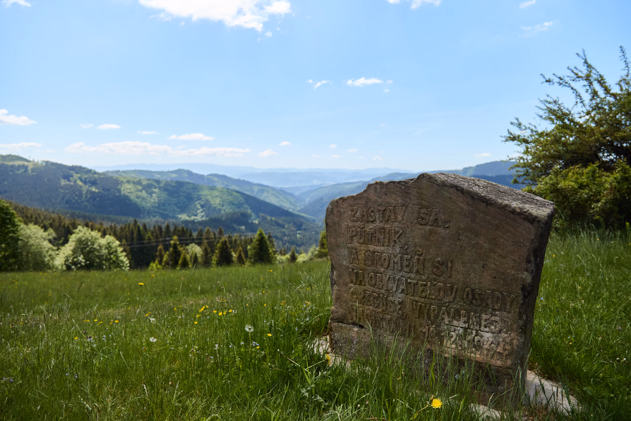 Pamätný kameň s nápisom „Zastav sa, pútnik…“ na lúke nad údolím Javorníkov