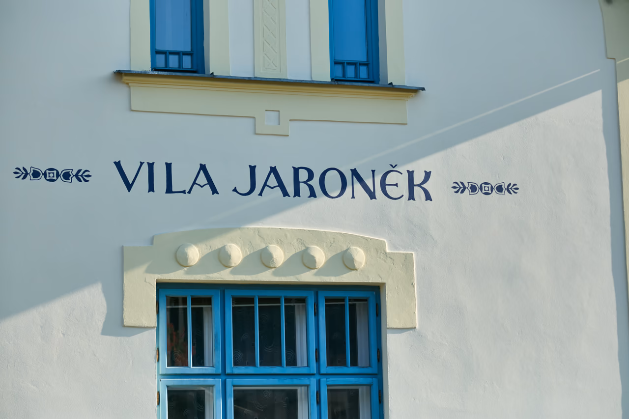 Detail nápisu Vila Jaroněk nad okny se zdobenou římsou