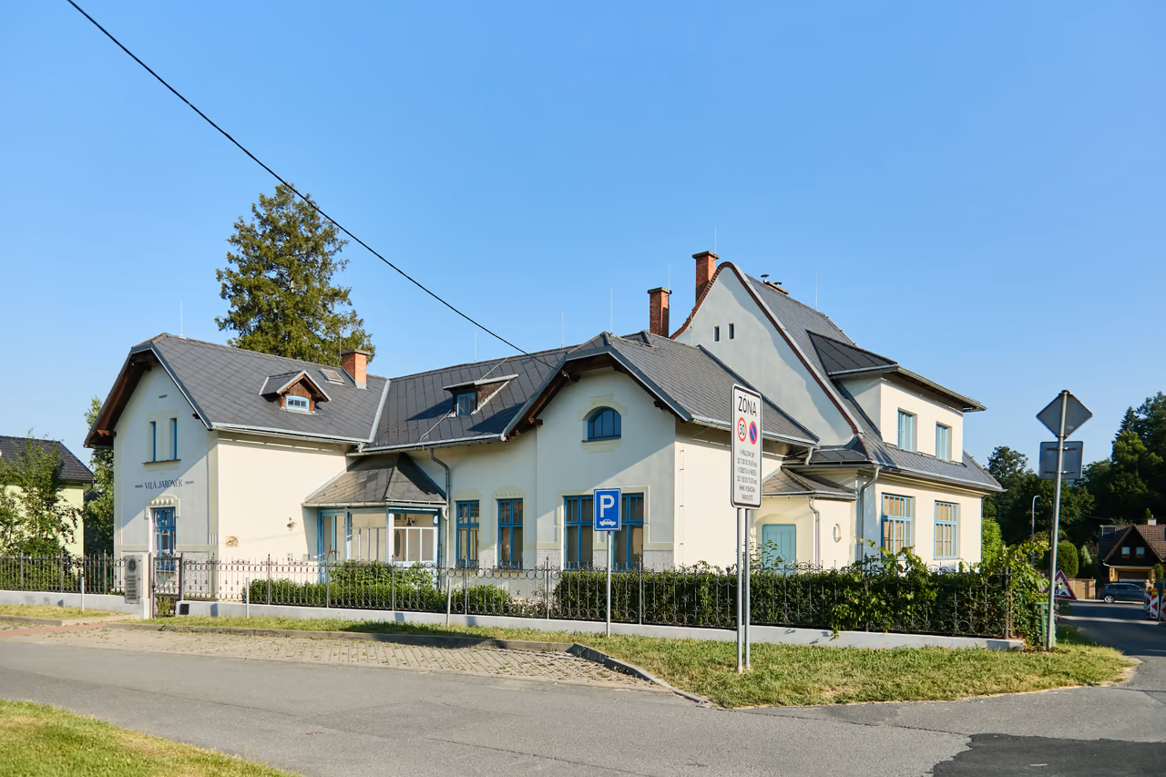 Jaroňkova vila v Rožnově pod Radhoštěm od ulice - členitá stavba s vikýři a modrými okny