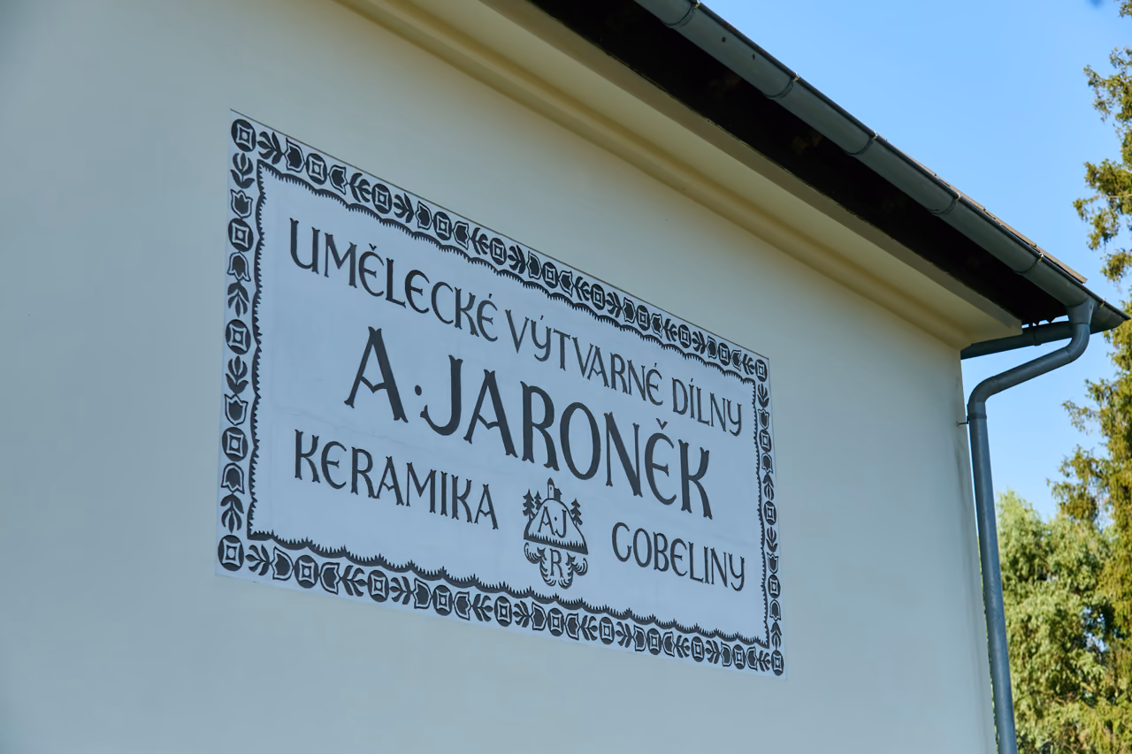 Nápisová deska na fasádě vily: Umělecké výtvarné dílny A. Jaroněk, keramika, gobelíny