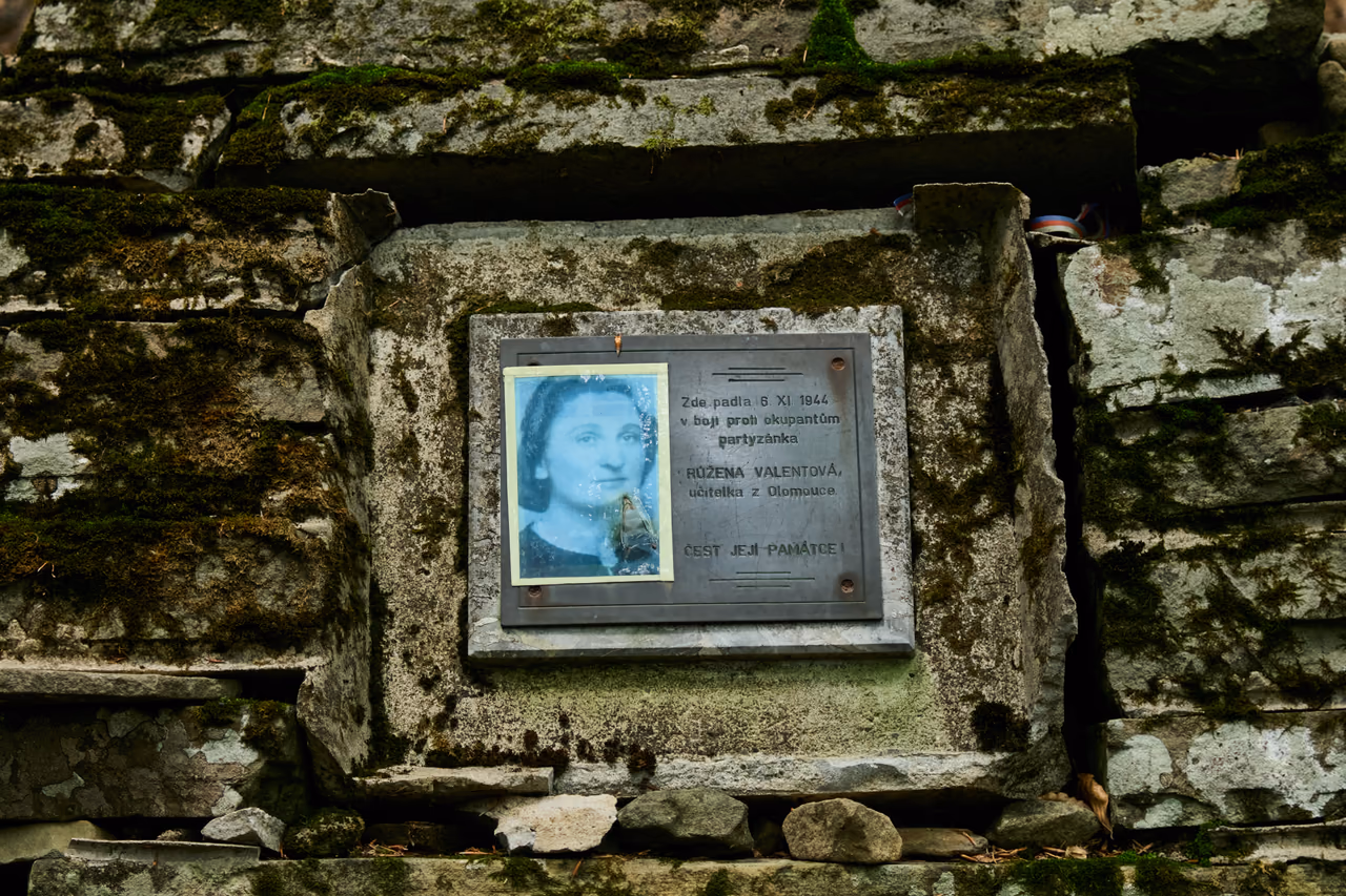Detail pamětní desky s fotografií Růženy Valentové zasazené do kamenné zdi