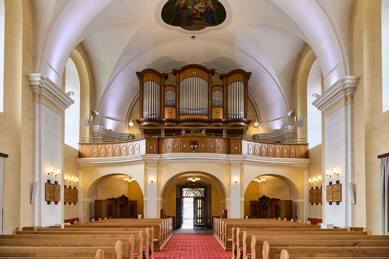 Widok nawą główną w stronę chóru z organami, po bokach rzeźby w drewnie drogi krzyżowej