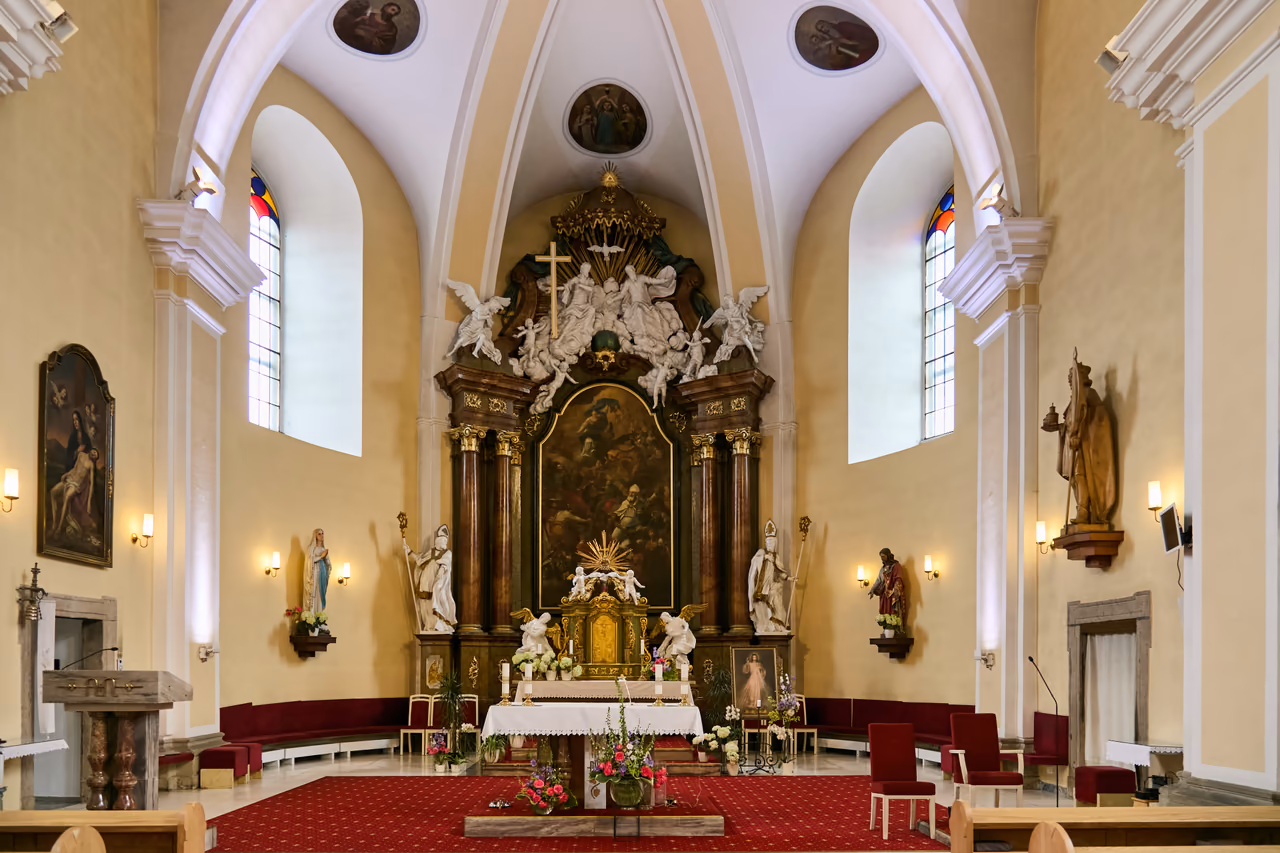 Prezbiterium kościoła z barokowym ołtarzem głównym, obrazem Wszystkich Świętych i figurami biskupów po bokach
