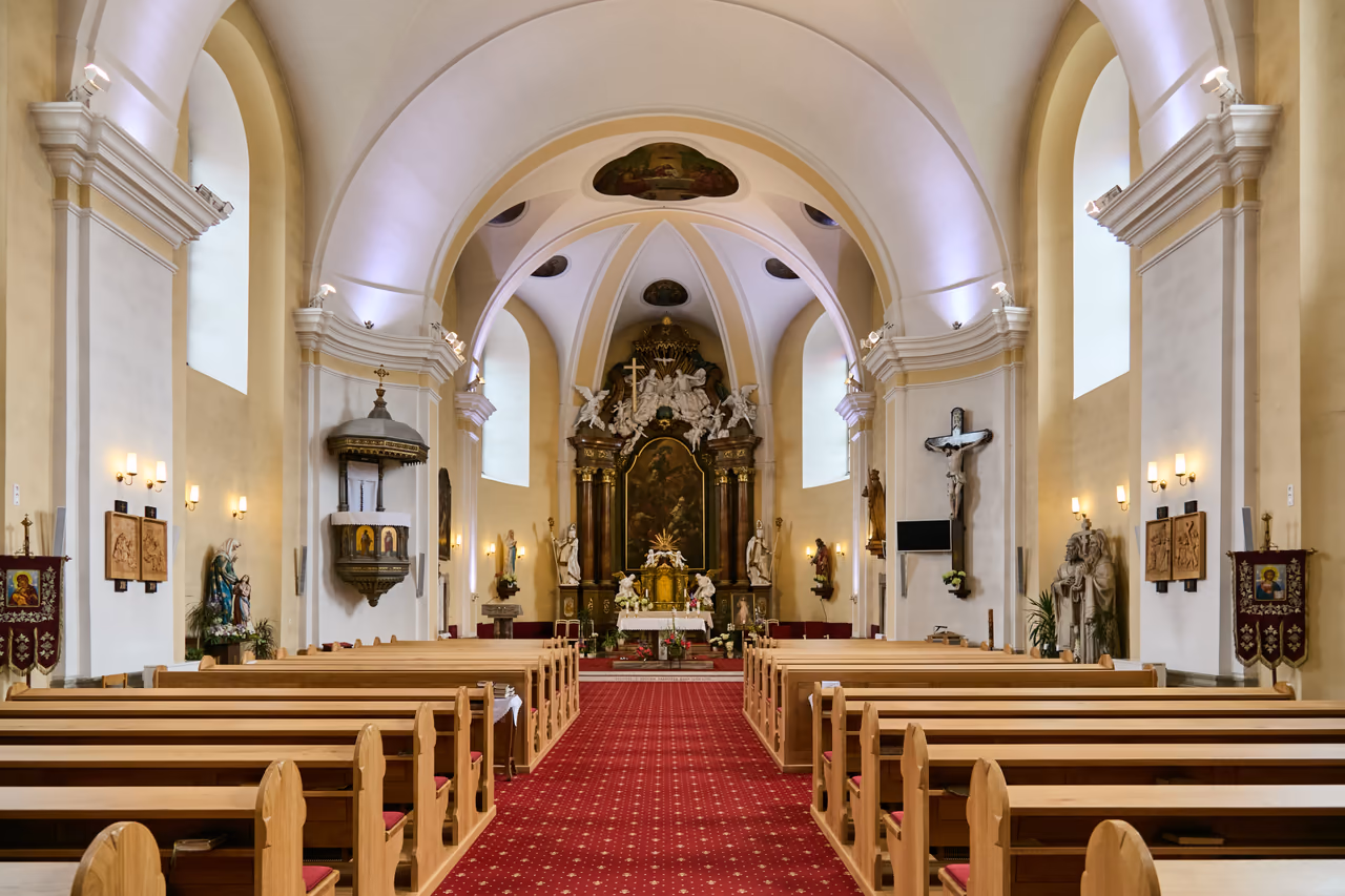 Nawa główna kościoła z ławkami, amboną i widokiem w stronę barokowego ołtarza