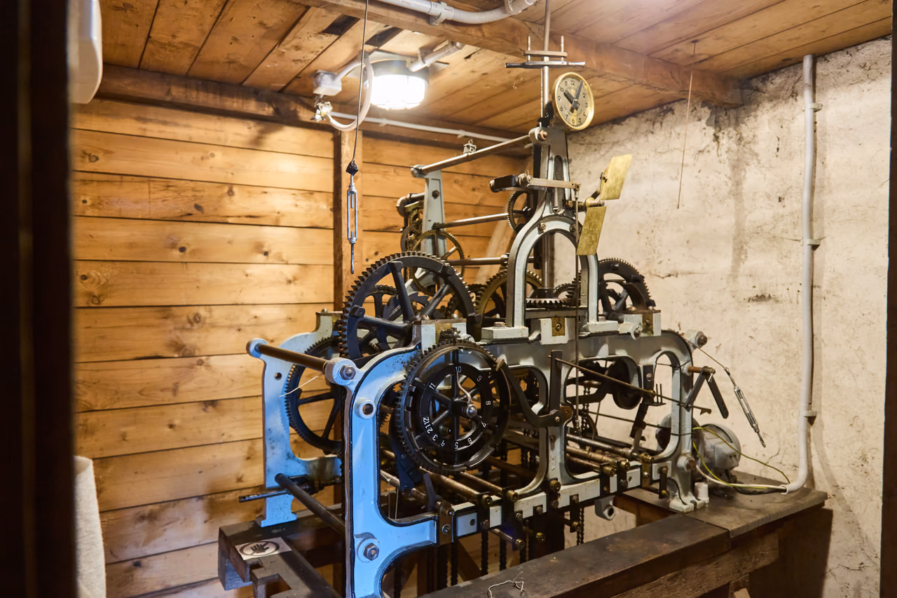 Historyczny mechanizm zegara kościelnego z kołami zębatymi i małą tarczą