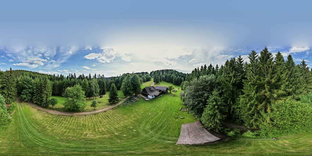 Kulová panoramatická fotografie z louky před chalupou v sedle pod Kotlovou - dřevěné stoly a lavice pod vzrostlým stromem, vpravo chalupa, kolem dokola les