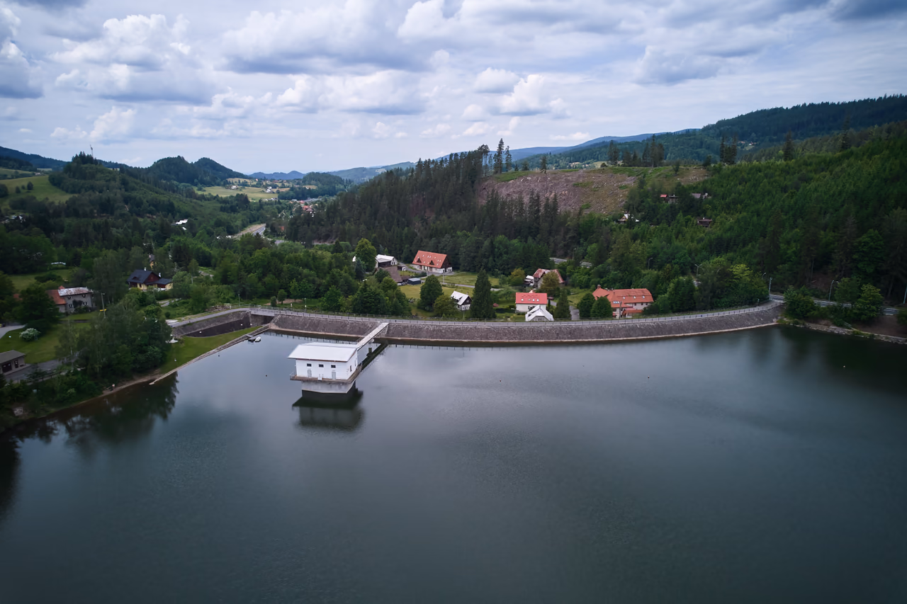 Die wasserseitige Böschung des Damms, befestigt mit Steinsatz und Pflaster, in der Mitte das Turmbauwerk mit dem Steg von der Dammkrone