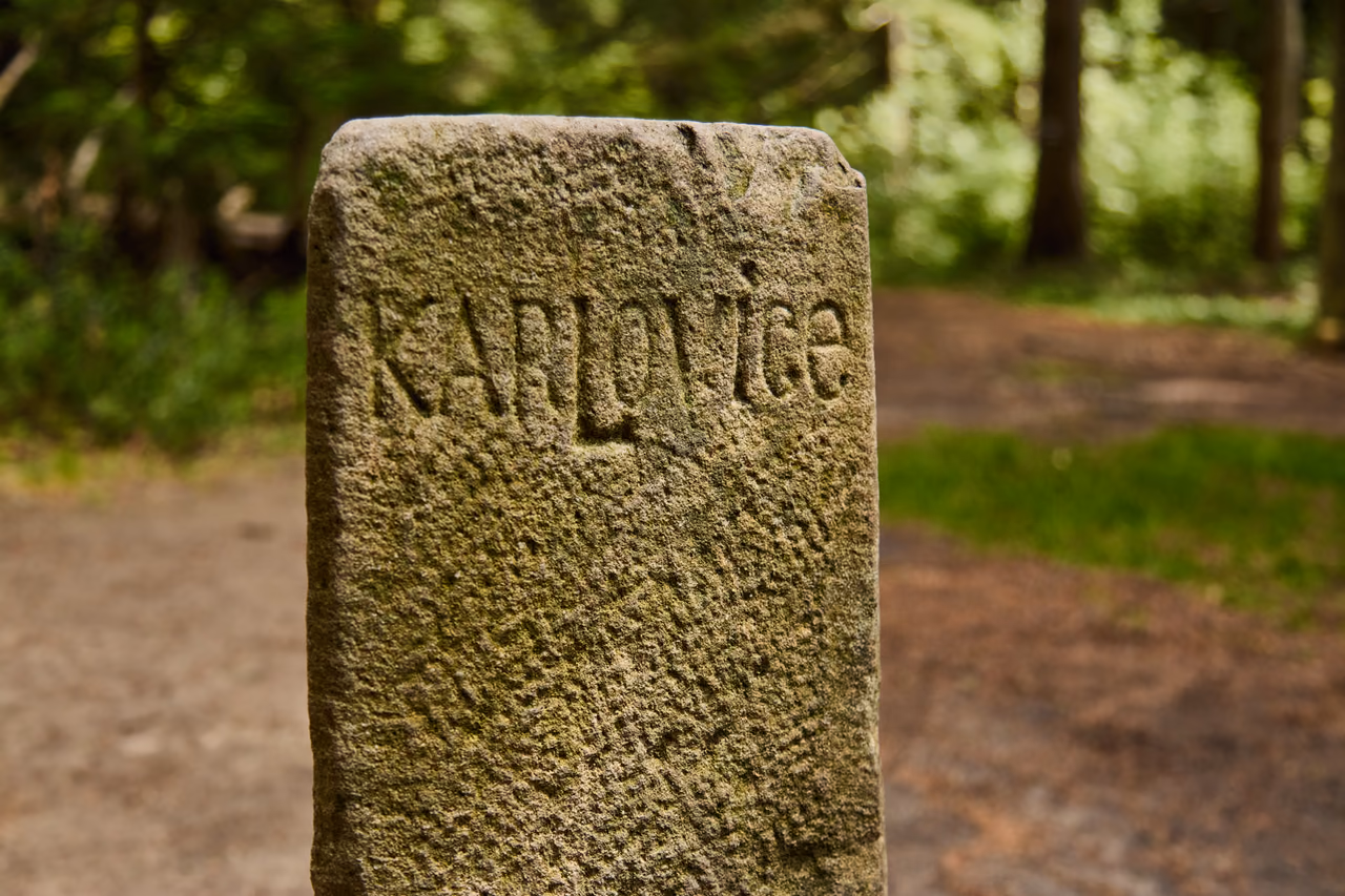 Detail strany hraničního kamene s vytesaným nápisem KARLOVICE