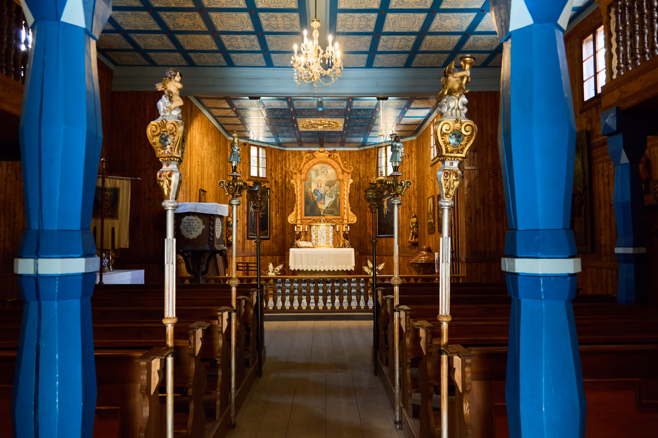 Blick durch das Kirchenschiff zum Hauptaltar, blau bemalte Säulen und Kassettendecke