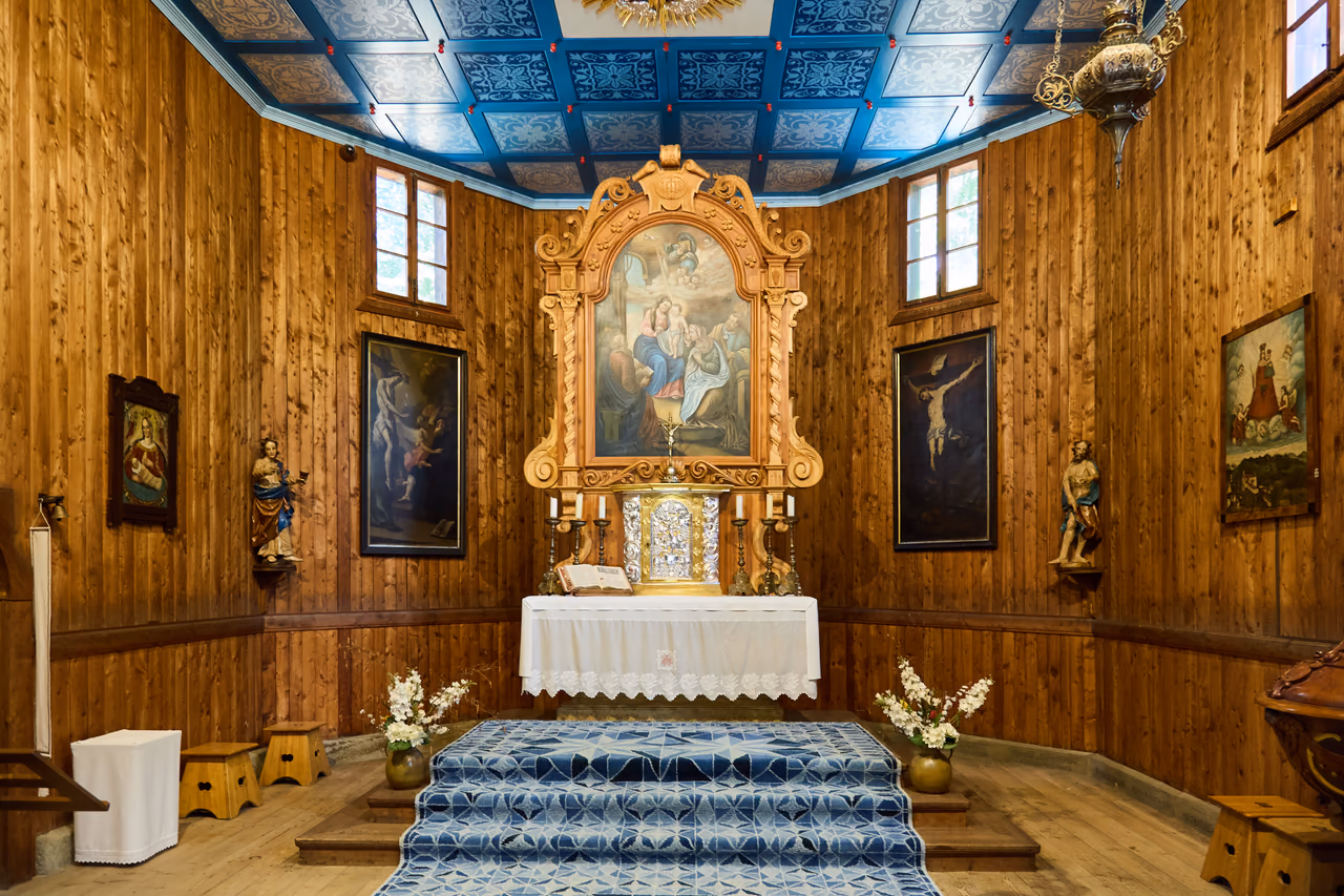 Chorraum der Kirche mit dem Hauptaltar, an den Seiten hängende Bilder und Heiligenfiguren