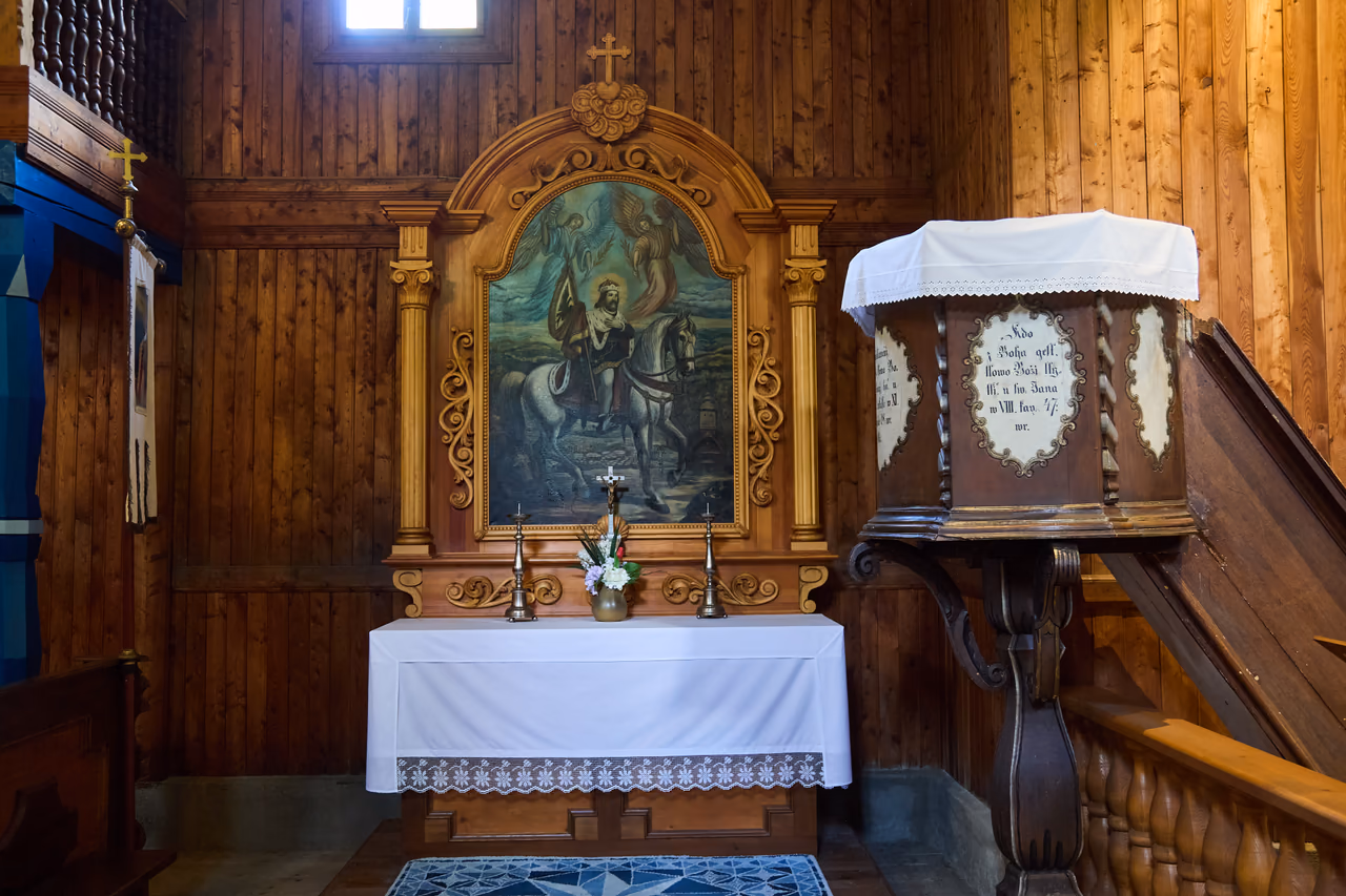 Seitenaltar der Kirche mit dem Bild des heiligen Wenzel zu Pferde, daneben eine hölzerne Kanzel