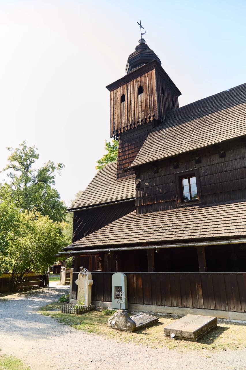 Seitenwand der Kirche der hl. Anna mit dem Turm darüber, am Fuß des Baus stehen alte Grabsteine