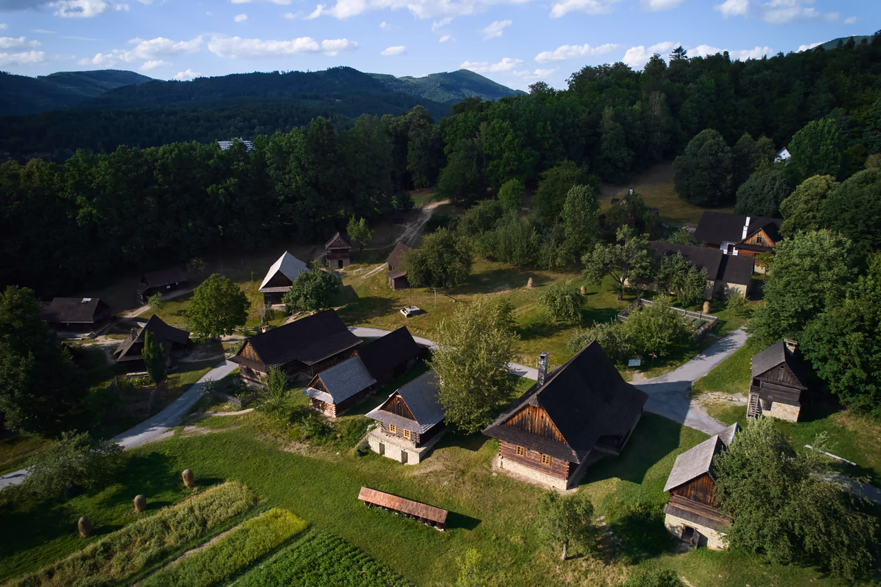 Cottages of the Wallachian Village with small fields, haycocks and pasture between them