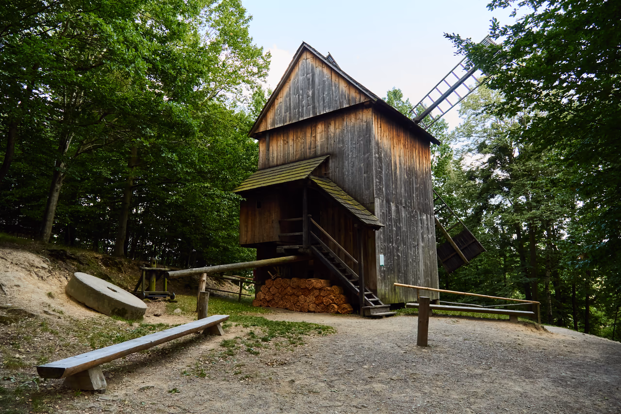 The windmill from Kladníky in the Wallachian Village, with an old millstone in front of it